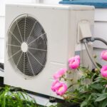 Heat pump in yard with flowers
