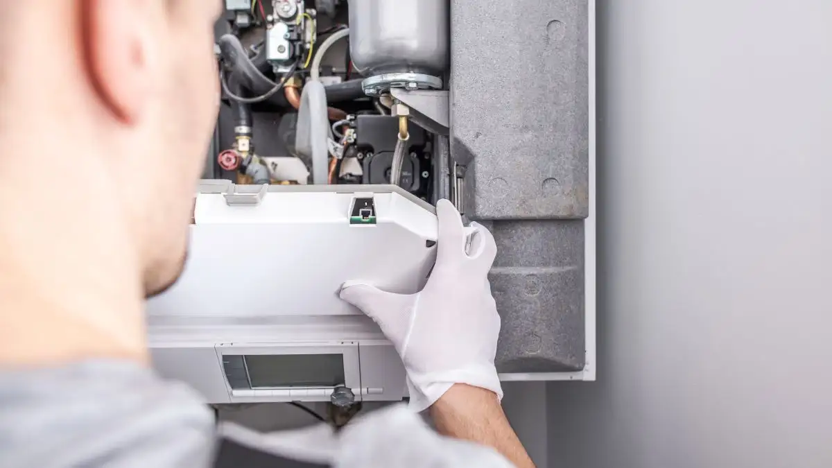 A technician repairing a home furnace system.